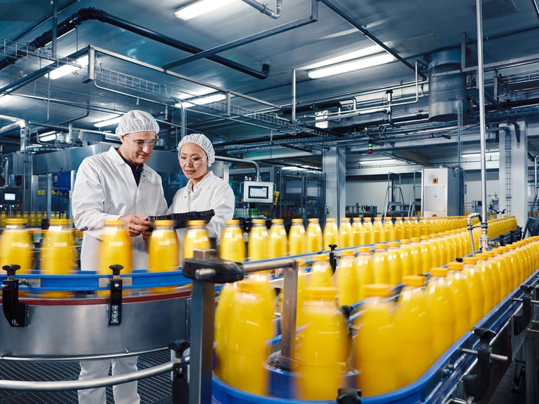 Riempimento di confezioni di succo d'arancia in un impianto di produzione di bevande